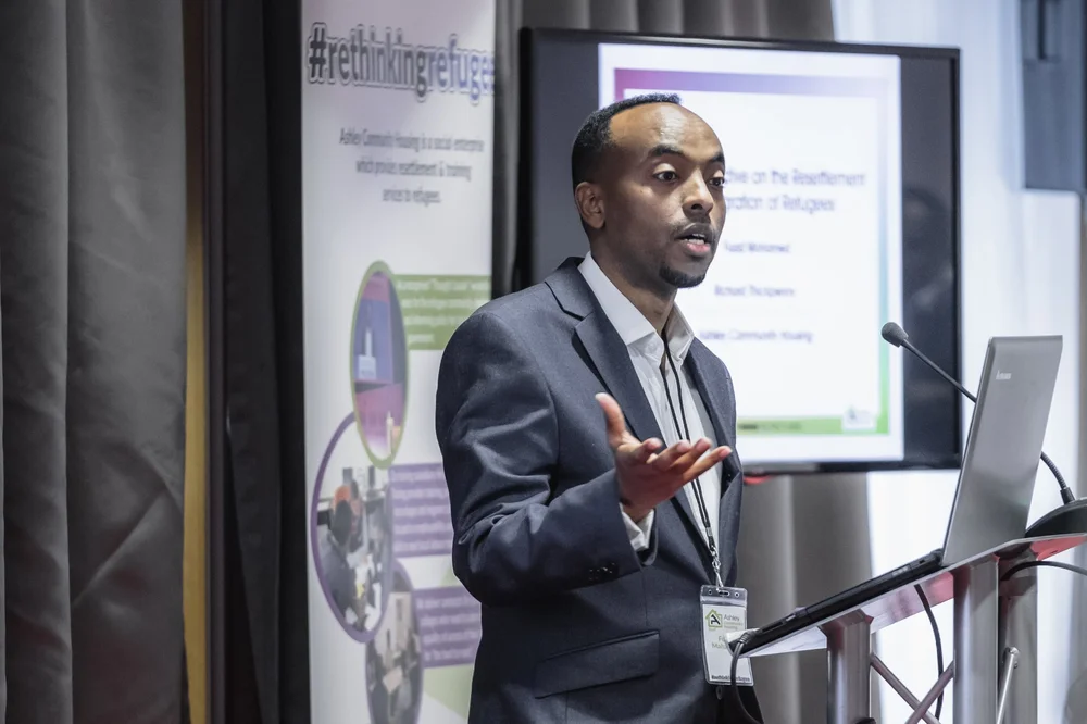 Fuad Mahamed stood on a stage giving a presentation to an audience