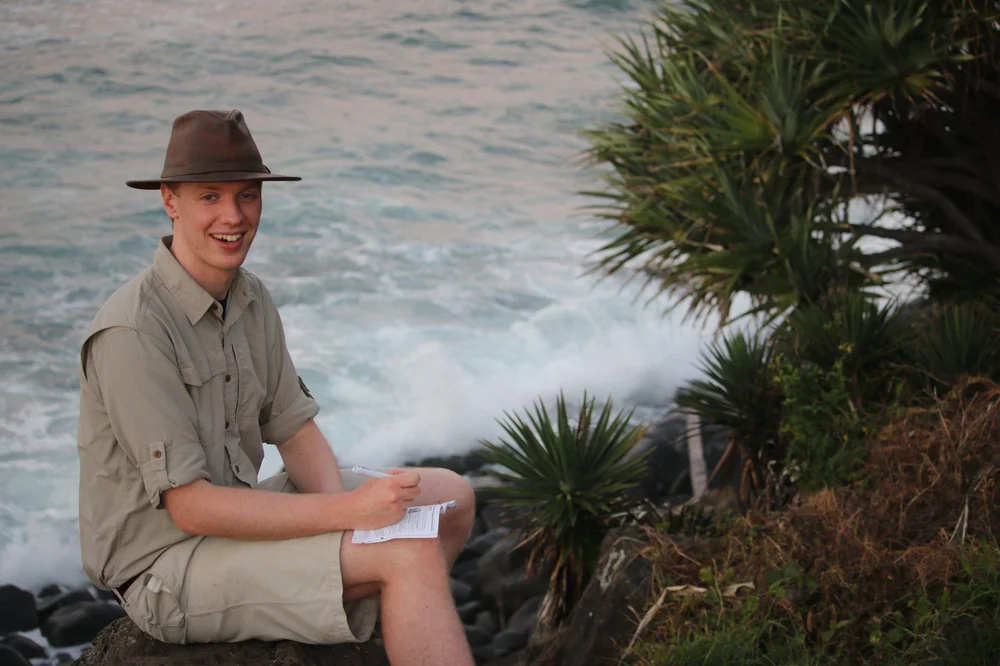 Joshua Powell sitting next to a lake